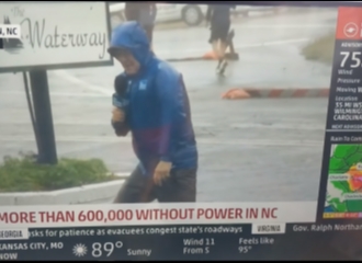 Seorang Reporter Secara Dramatis Bertahan dari Angin Badai Saat Membawakan Berita, Dan 2 Orang Pria Berjalan Santai Di Belakangnya
