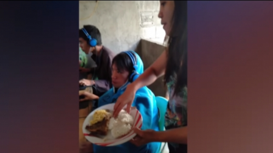 Seorang Ibu Menyuapi Anaknya yang Ketagihan Video Game di Sebuah Internet Cafe di Filipina
